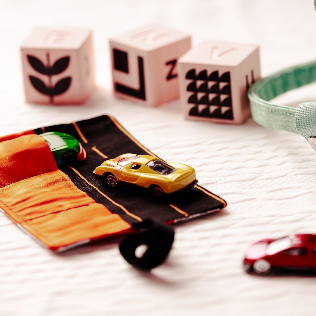 5fef922b396f5759083117ff_toy-cars-sitting-on-and-in-the-pocket-of-the-car-wallet_1780346110270.jpg